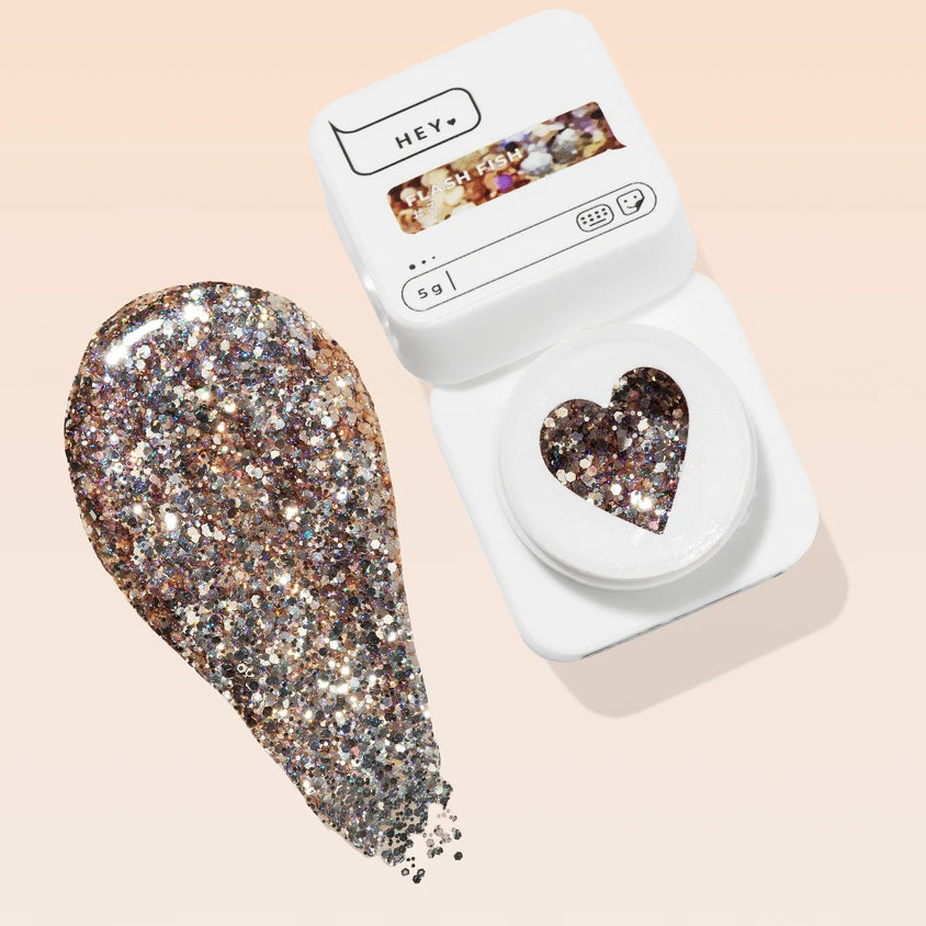 Open container of silver and gold glitter gel for nails with a heart-shaped window and gel swatch
