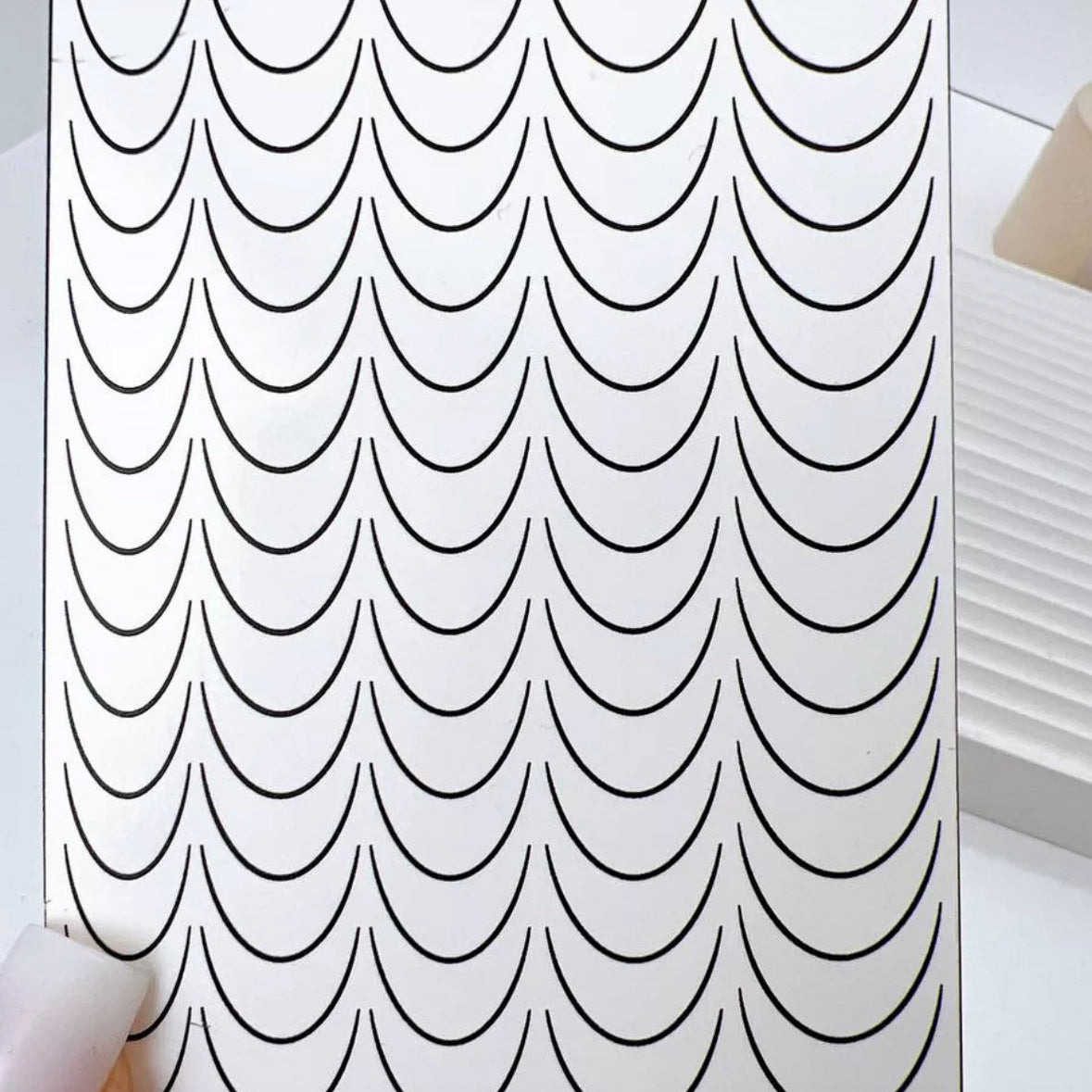 Nail art stencil sheet with black curved French tip guides for manicure designs