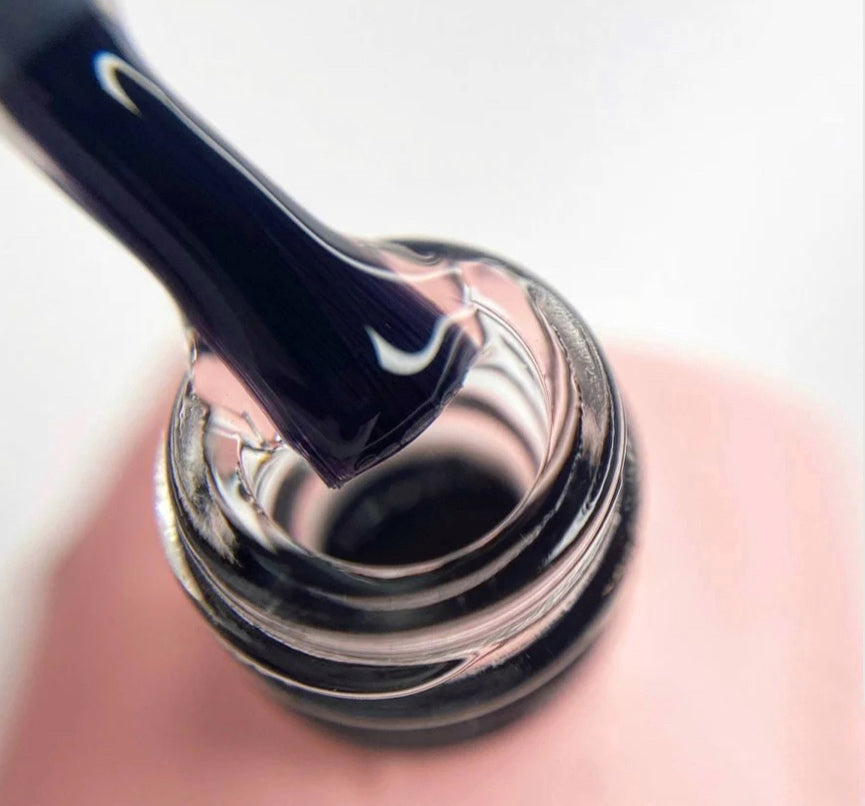 Close-up of nail polish brush with clear UV gel, professional manicure supplies