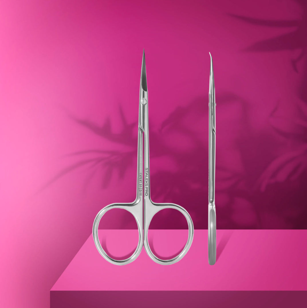Stainless steel cuticle scissors for manicure on pink background, professional nail tool