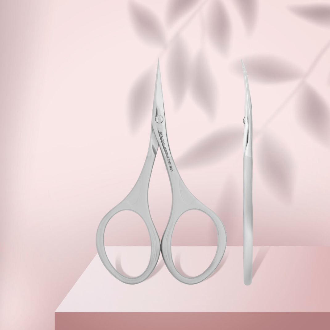 Stainless steel manicure scissors curved blade for nail and cuticle trimming on pink background