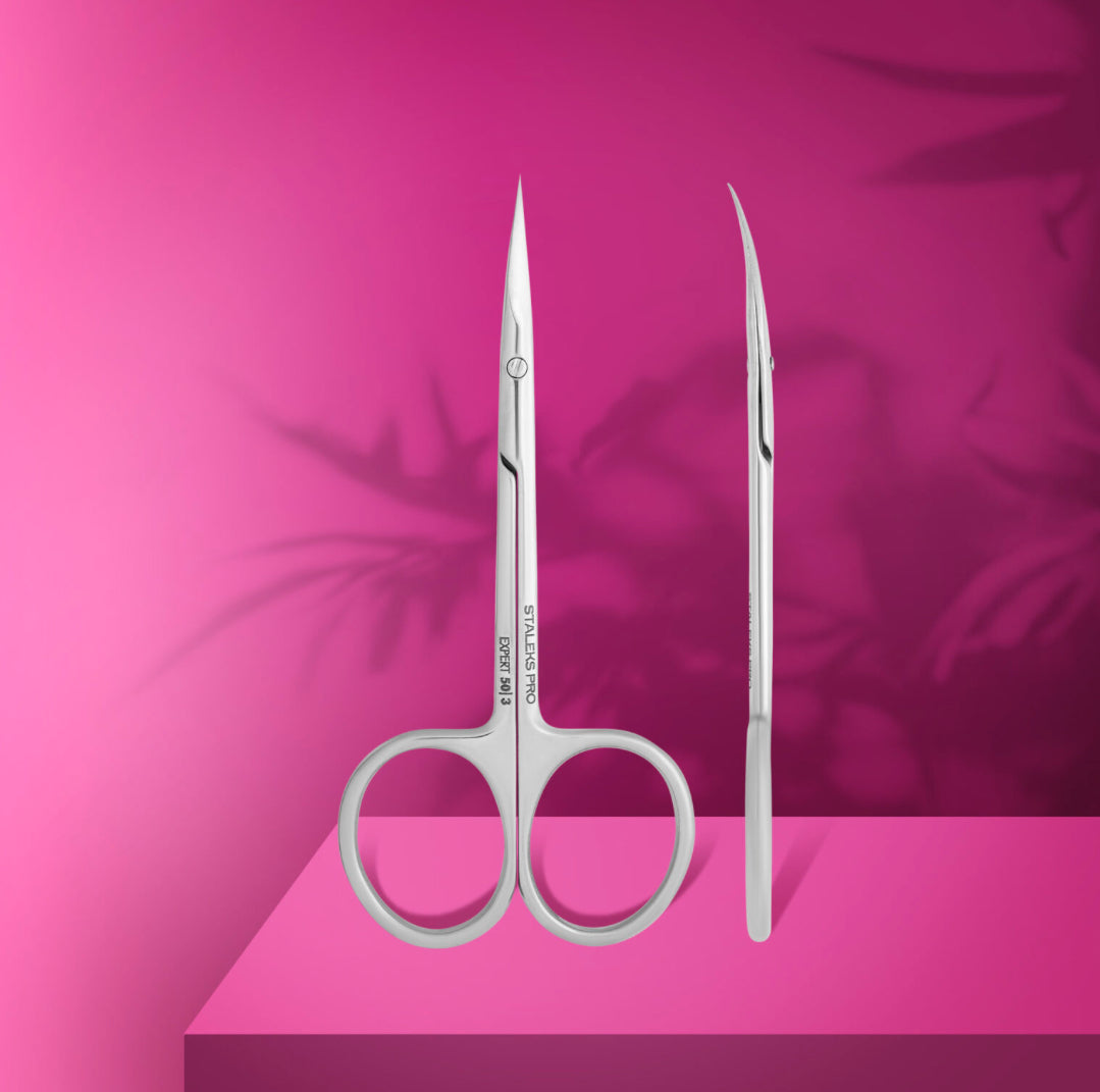 Stainless steel professional nail scissors with fine curved blades on pink background