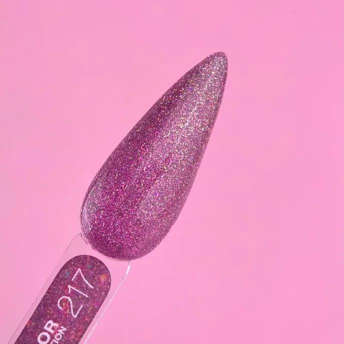 Glittery purple gel nail polish swatch, stiletto shape on neutral pink background