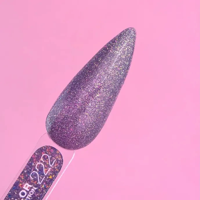 Shimmery purple glitter gel nail polish swatch on display stick against pink background