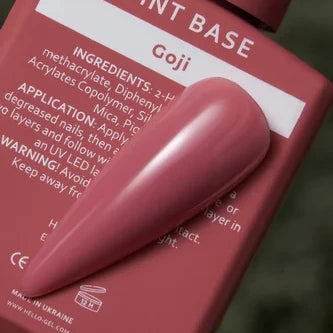 Swatch of glossy mauve gel nail polish on nail tip against bottle labeled Goji.