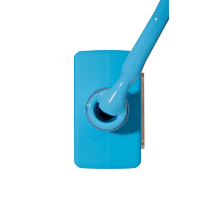 Bright blue nail polish bottle with applicator brush, professional manicure product