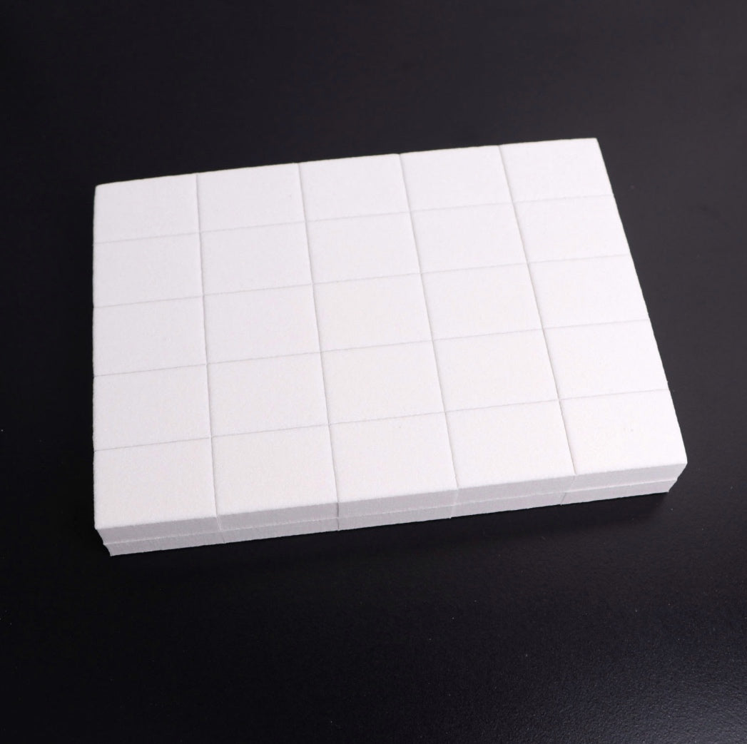White rectangular nail art sponge blocks set for manicure on black background