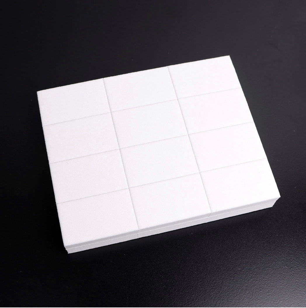 White nail art sponge blocks for manicure and pedicure on a black background