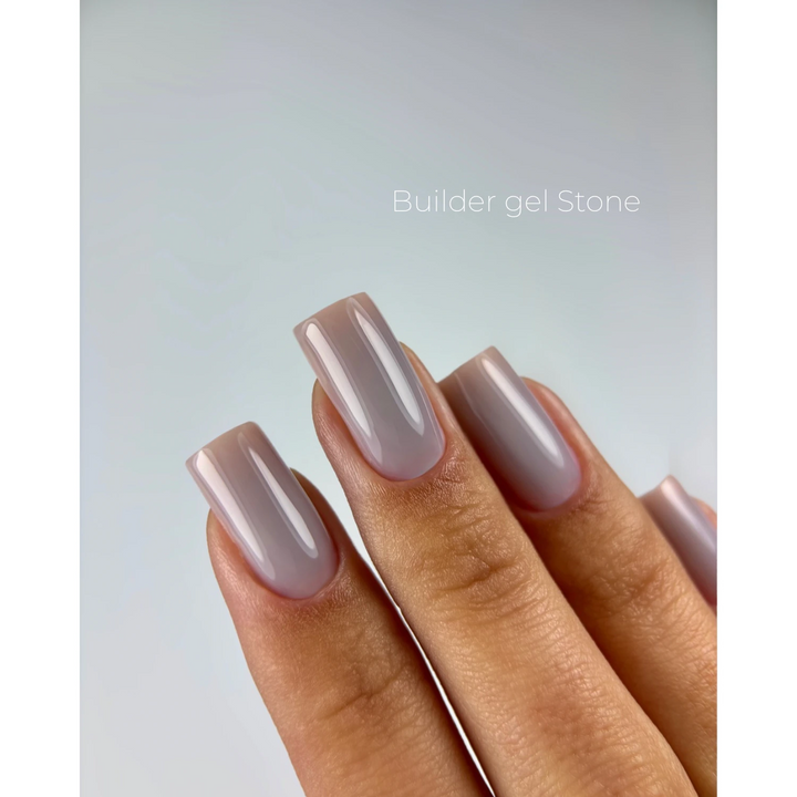 A close-up of a hand with long, square-shaped nails painted in a glossy, pale dusty lavender-gray gel polish, with the text &