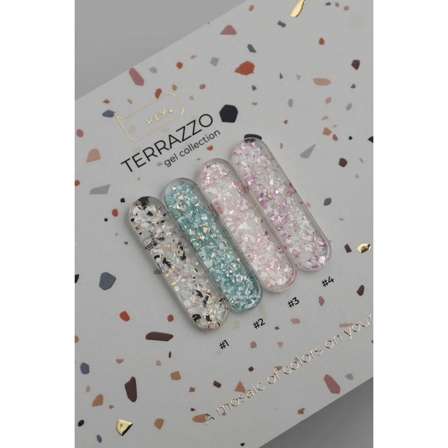 Terrazzo gel nail polish swatches with glitter on a sample card for manicure