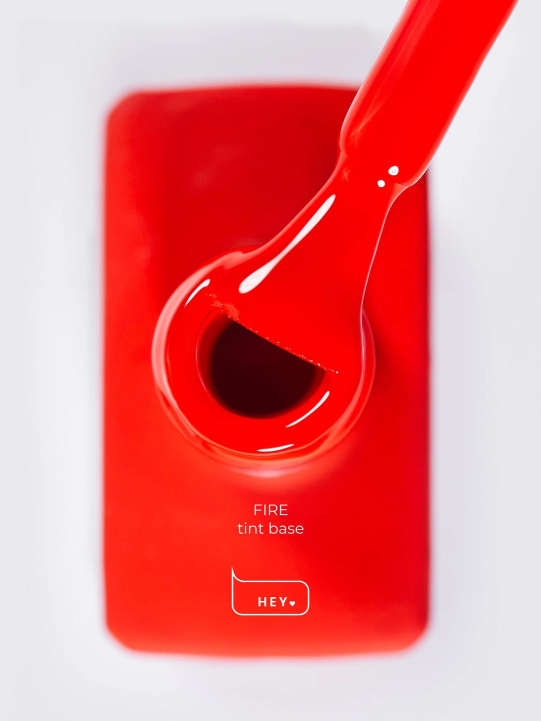 Red gel nail polish bottle with brush labeled Fire tint base, manicure product