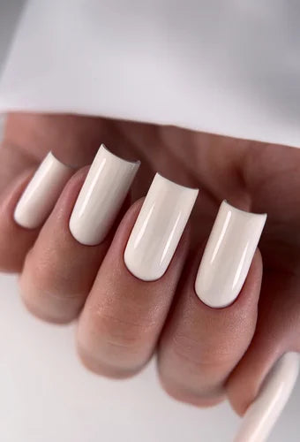 Hand with long square-shaped nails featuring glossy white gel polish manicure