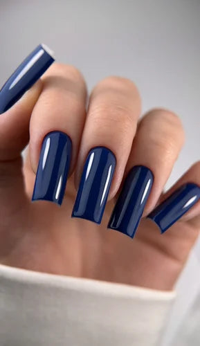 Hand with glossy dark blue square acrylic nails, manicure nail art close-up