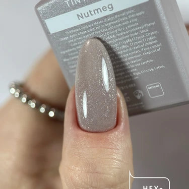 Hand with almond-shaped nail featuring glossy, shimmery nude Nutmeg gel polish