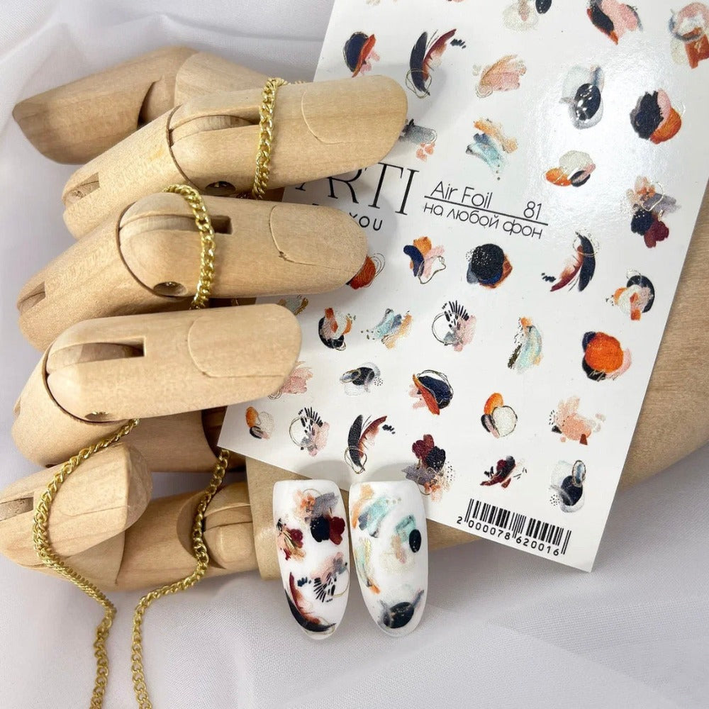 Abstract nail art stickers and decorated nail tips on a wooden hand display