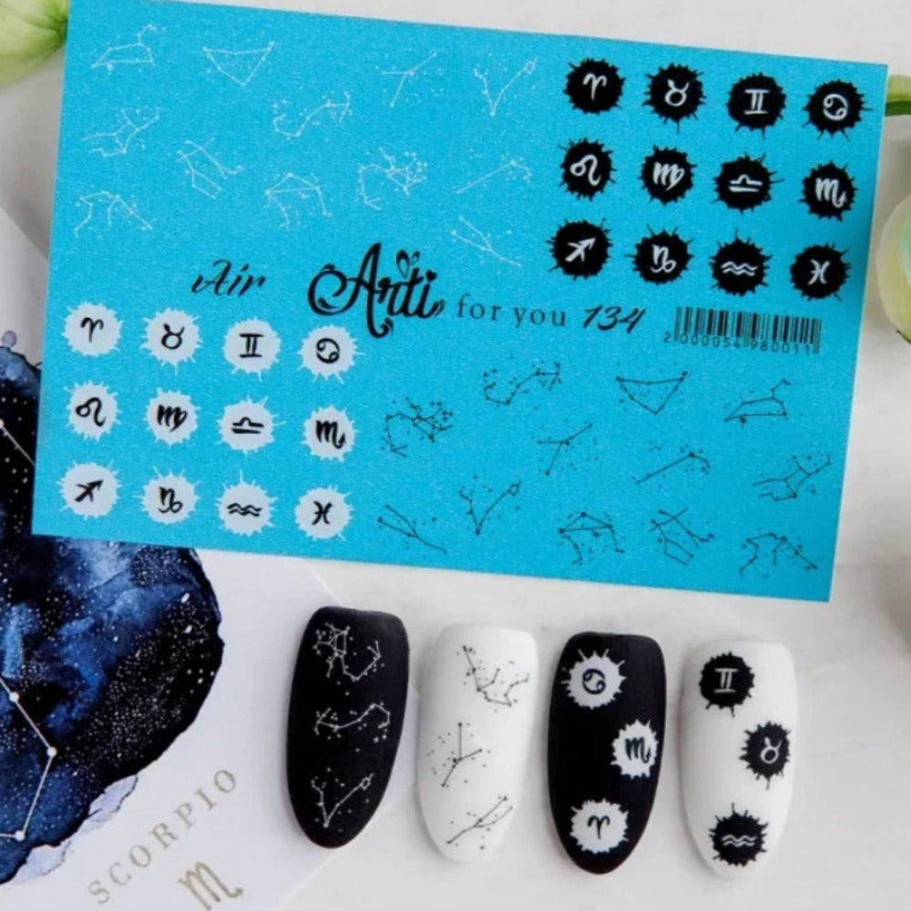 Zodiac constellation and symbol nail art stickers displayed with decorated black and white press-on nails