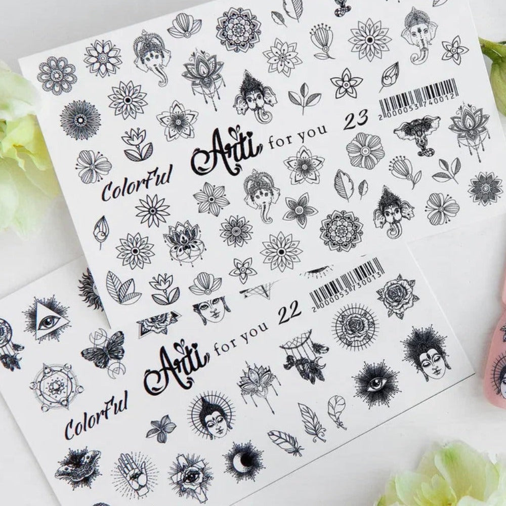 Nail art stickers with black and white floral, eye, Buddha, and mandala designs on sheets.