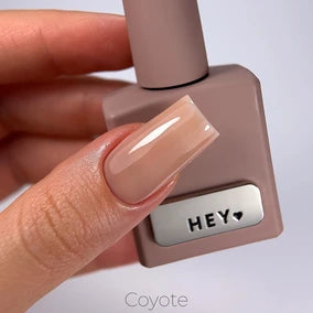 Hand holding nude gel nail polish bottle, long glossy manicure, professional nail product