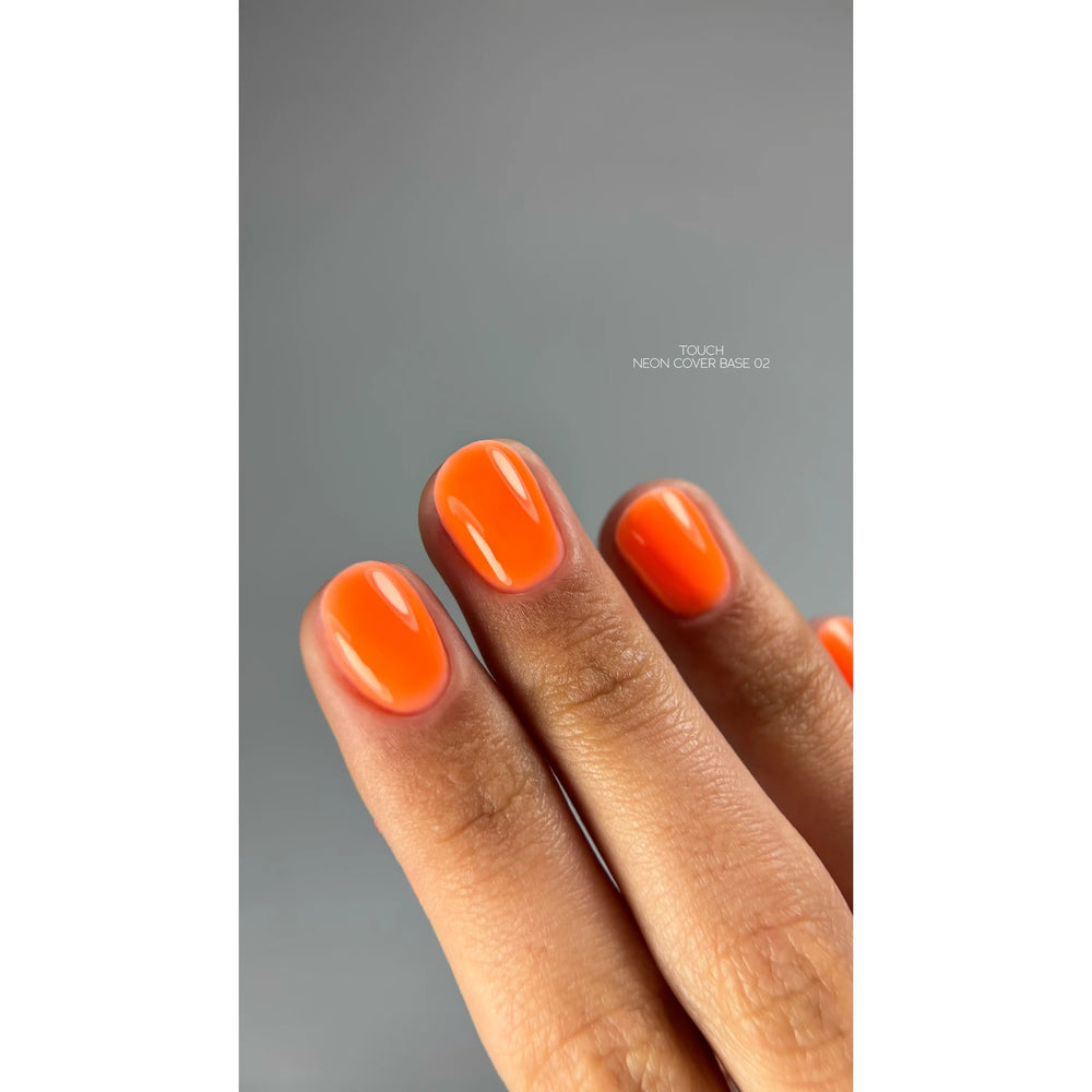 Hand with short nails painted in glossy neon orange gel polish, manicure close-up
