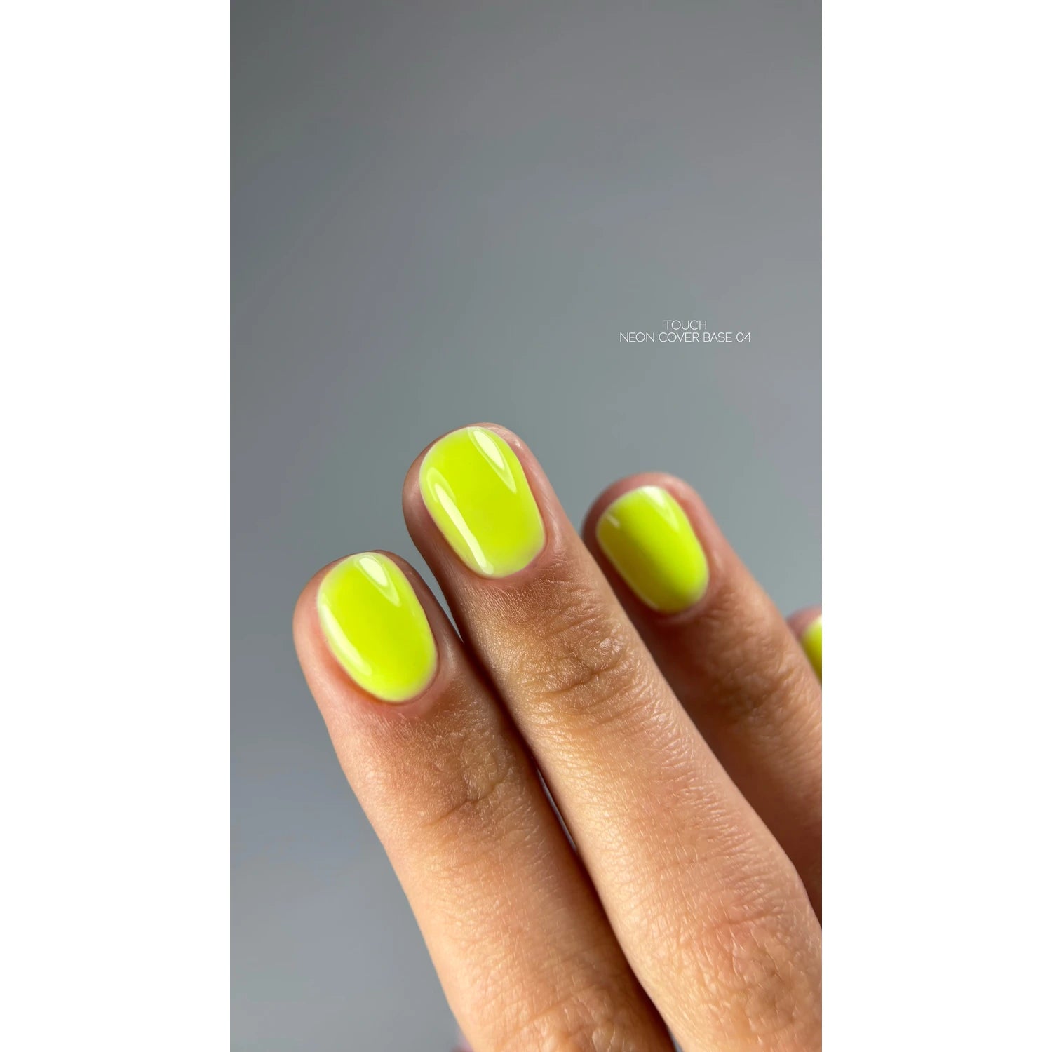 Hand with short nails painted neon yellow UV gel polish, manicure close-up