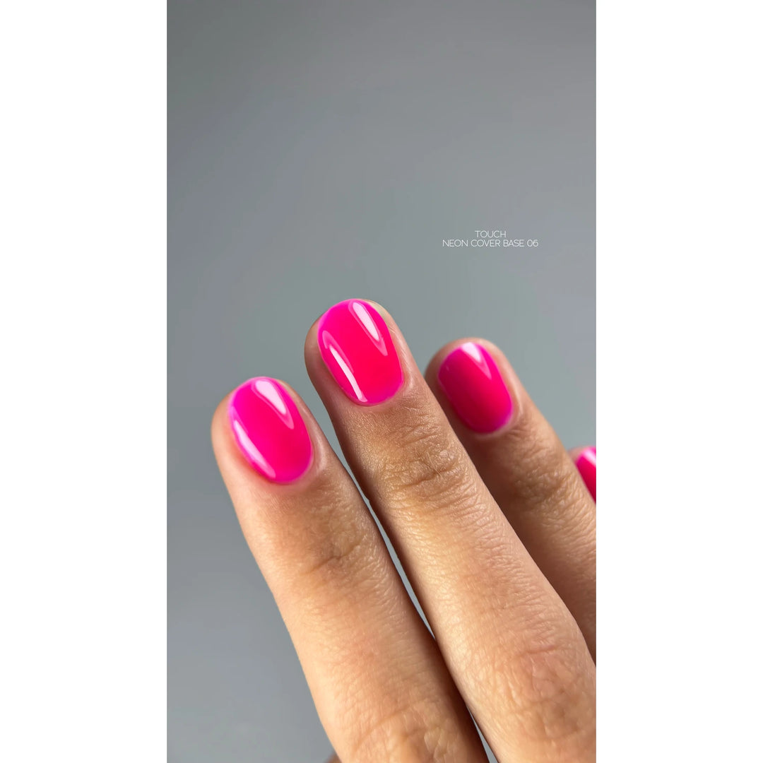 Hand with short nails painted glossy neon pink, professional manicure close-up