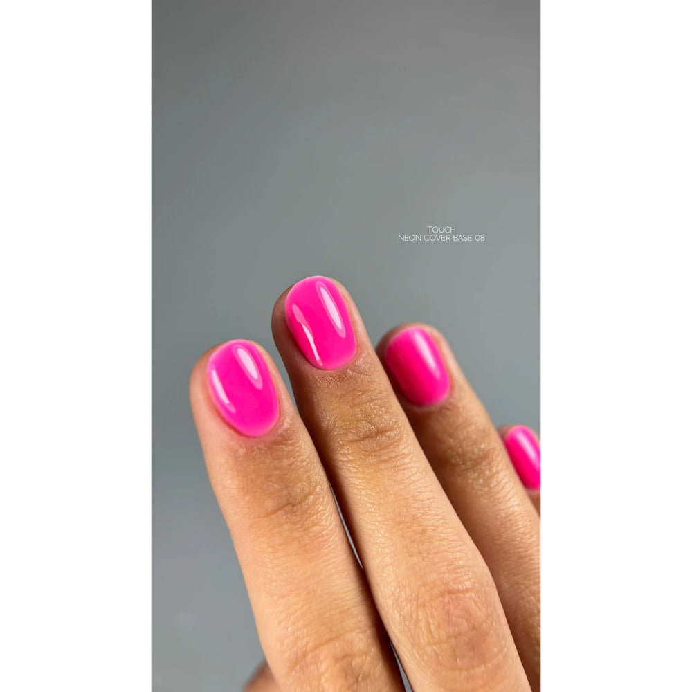 Close-up of hand with glossy neon pink gel nail polish manicure