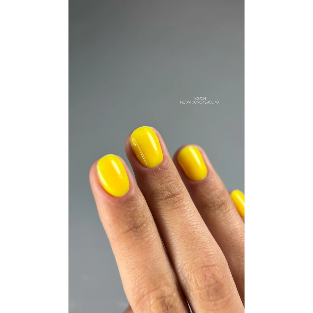Hand with short nails painted in glossy neon yellow nail polish, manicure close-up