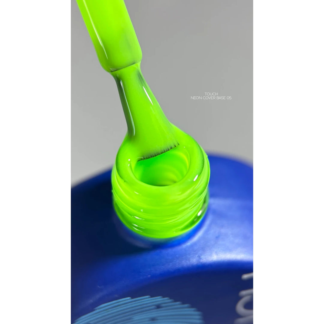 Neon green gel nail polish brush being pulled from blue bottle, close-up