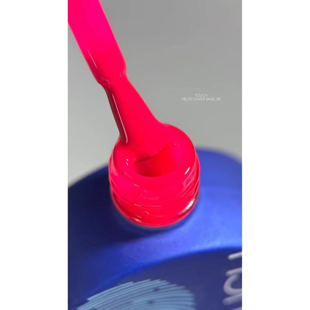 Neon pink nail gel polish brush above open blue bottle, close-up for manicure product