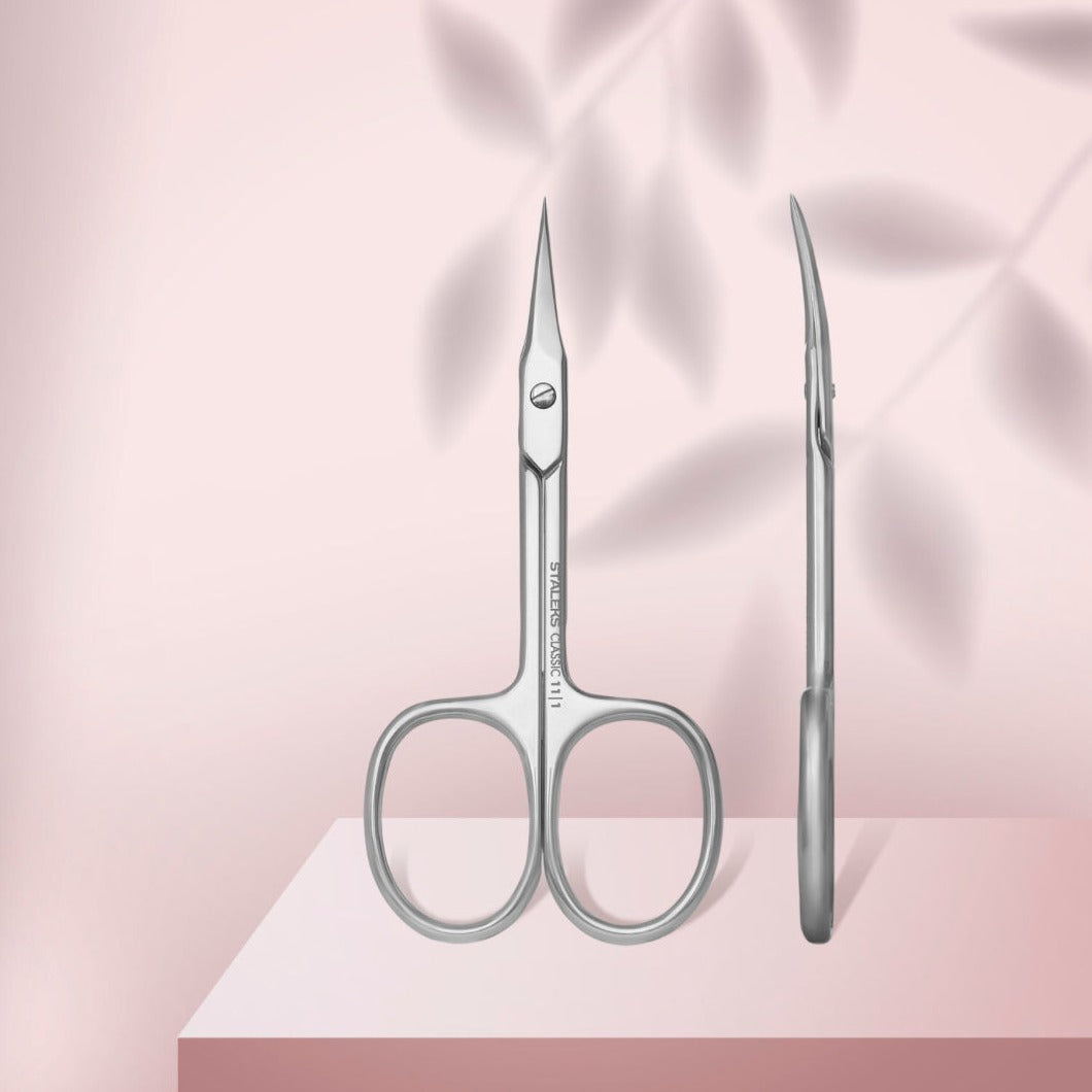 Stainless steel cuticle scissors for manicure on a pink background, shown front and side view