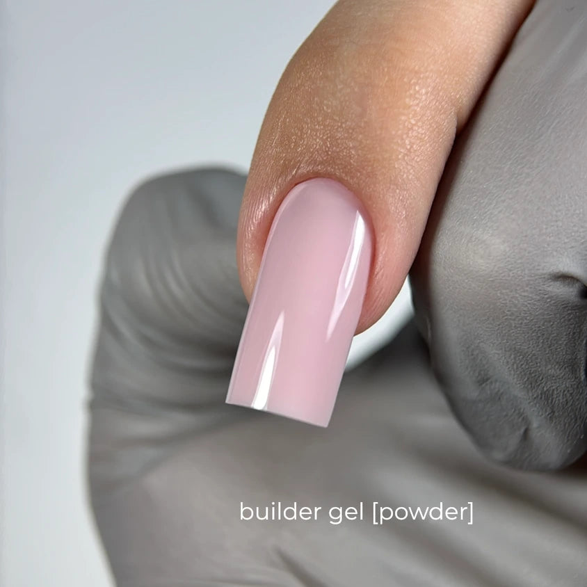 Hand with long pink builder gel nail, manicure using powder technique