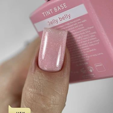 Close-up of a hand with a glossy pink manicure using Jelly Belly tint base polish