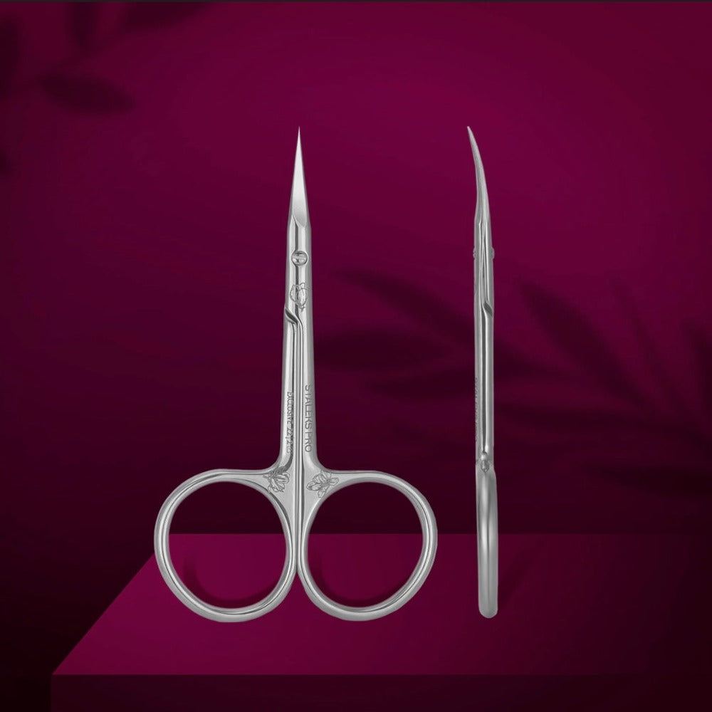 Stainless steel manicure scissors with sharp curved blades on a burgundy background