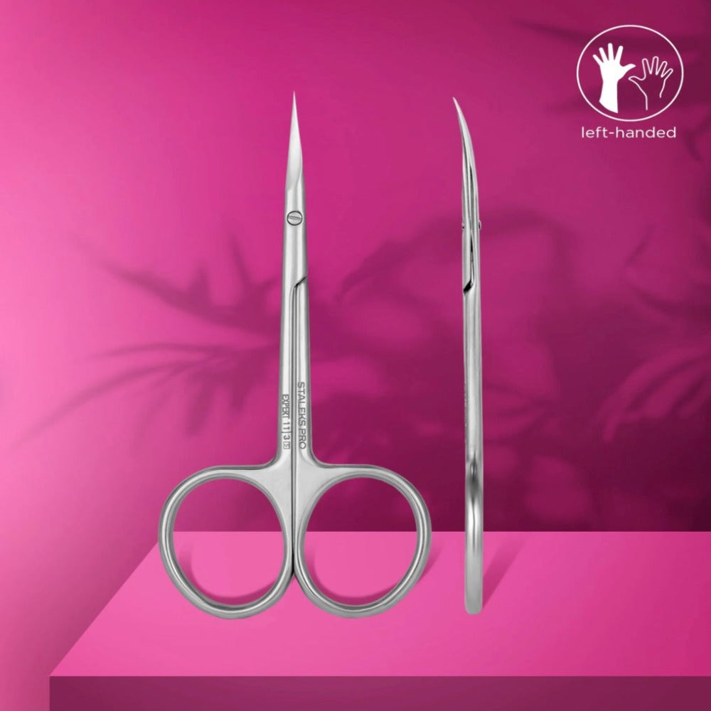 Left-handed stainless steel manicure scissors with fine pointed blades on a pink background