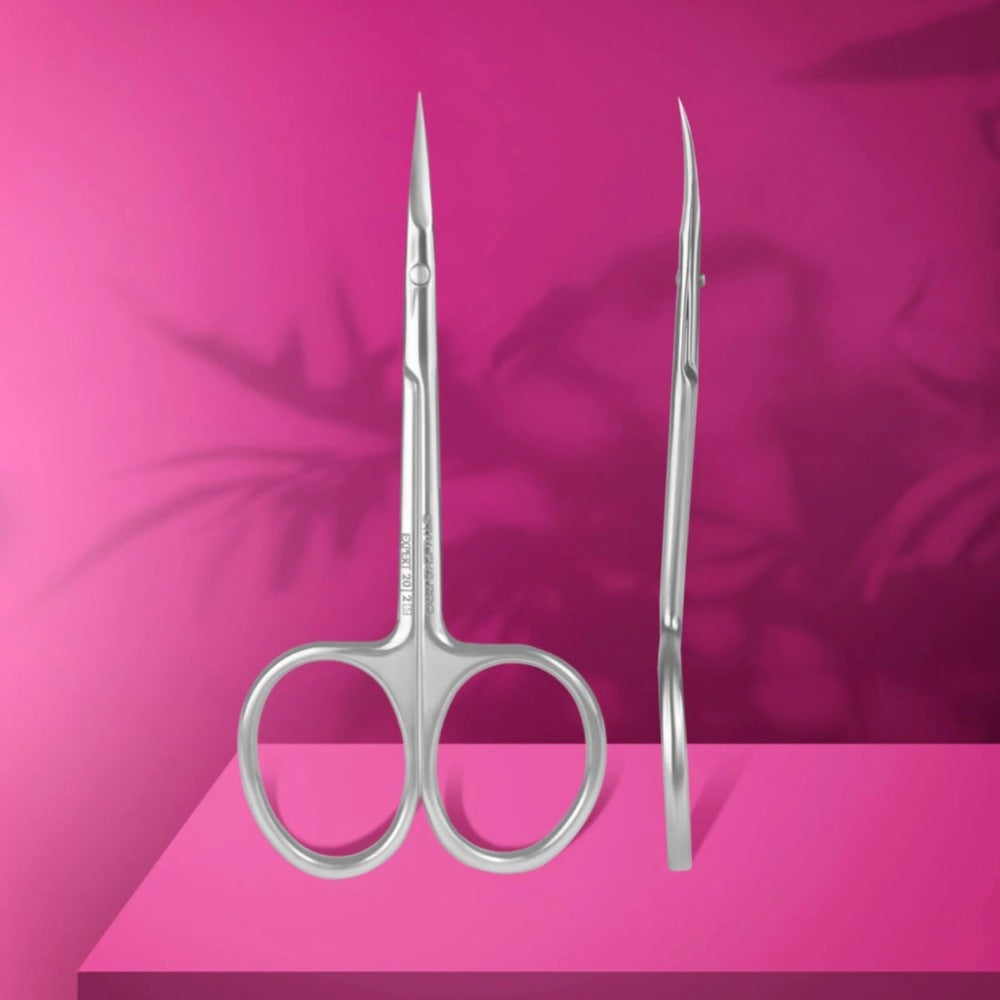 Stainless steel manicure scissors with curved tips on a pink background, nail care tool