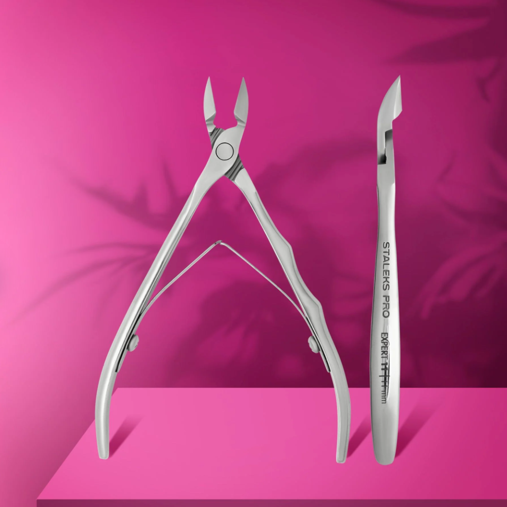 Stainless steel professional cuticle nippers and nail tool on pink background