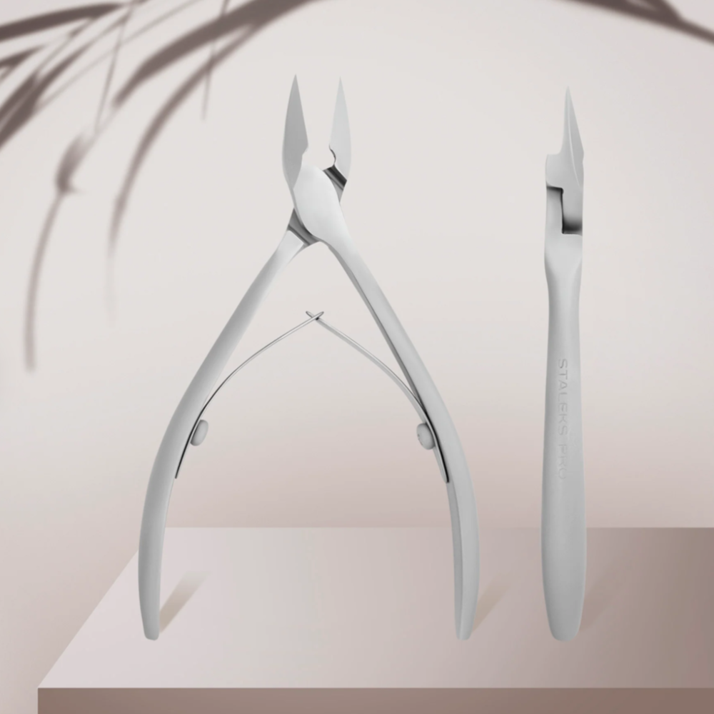 Stainless steel professional cuticle nippers for manicure and pedicure on neutral background
