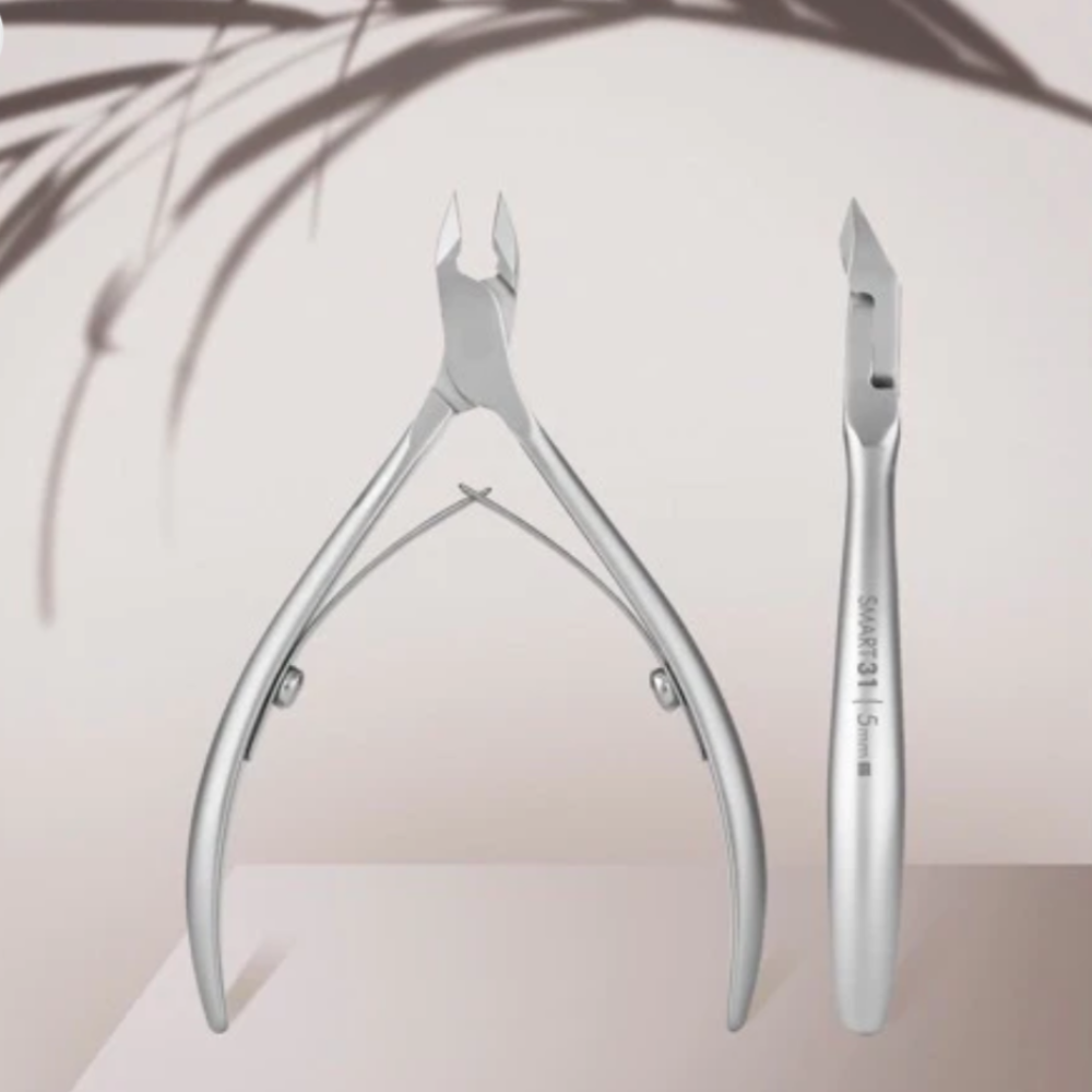 Stainless steel cuticle nippers for manicure and pedicure on a neutral background