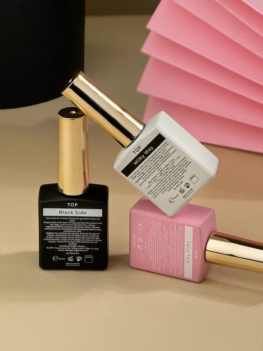 Three nail top bottles with  on a beige surface.