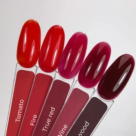 Five manicure nail polish swatches in red and burgundy shades on clear sample sticks