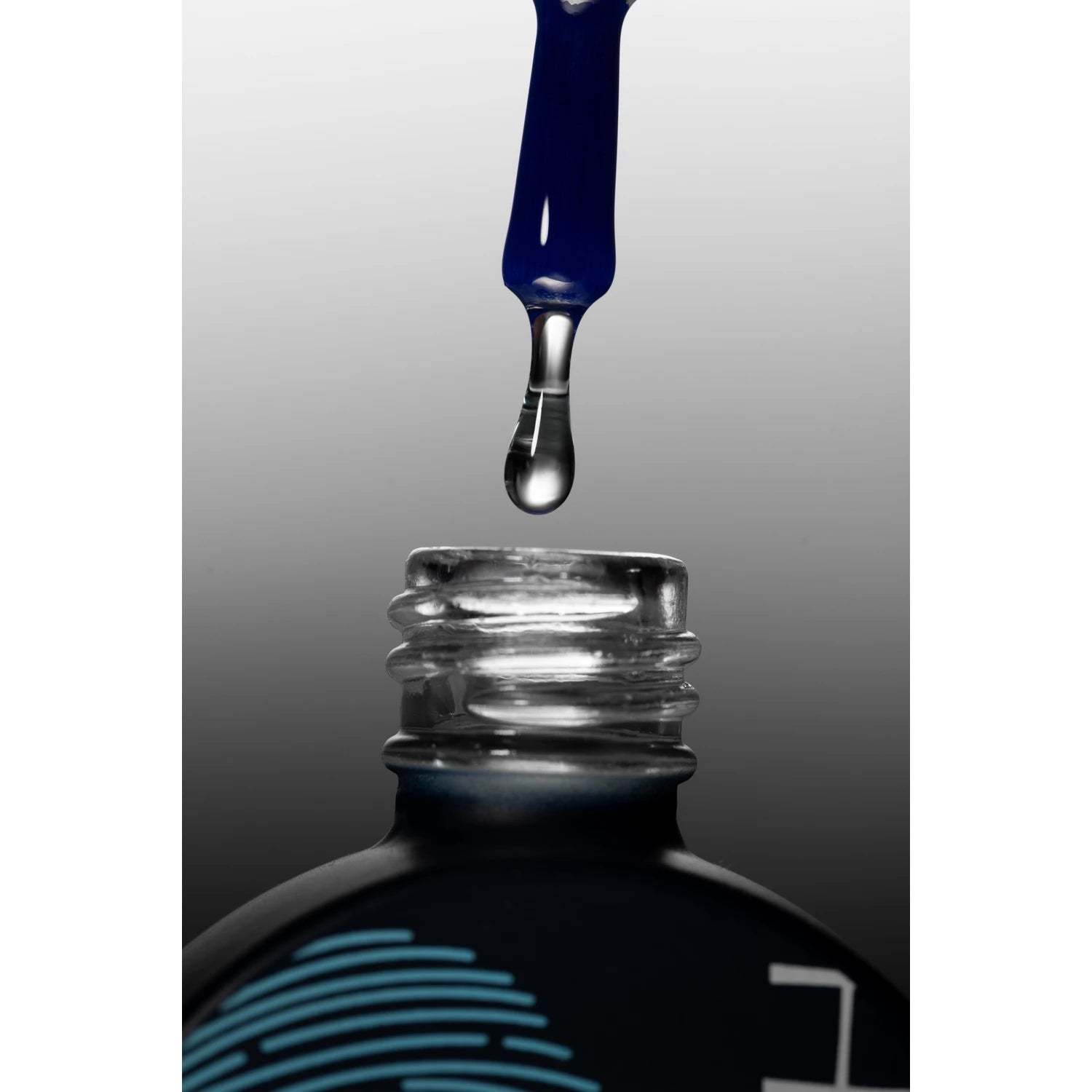 Clear nail polish dropper above open bottle, manicure and nail care product