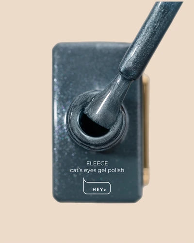Gray cat's eye gel polish bottle with applicator brush, professional nail product