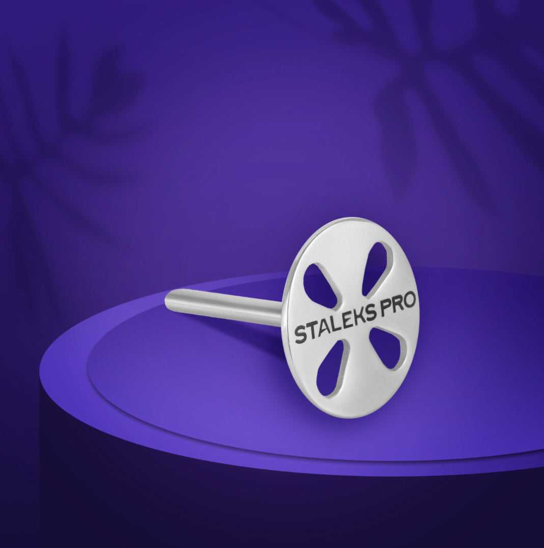 Metallic manicure tool bit with 'Staleks Pro' logo on a purple background