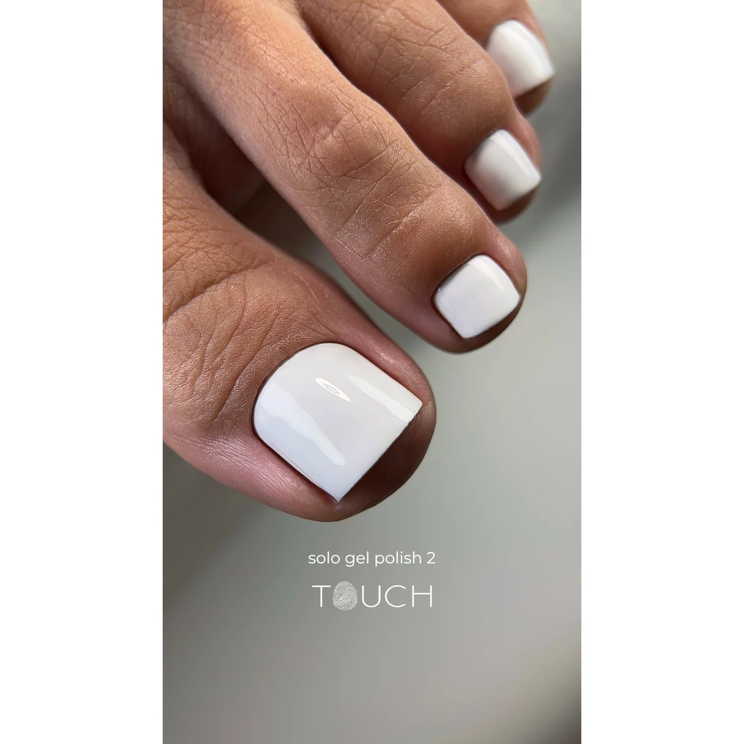Close-up of toes with glossy white gel polish pedicure, professional nail care.