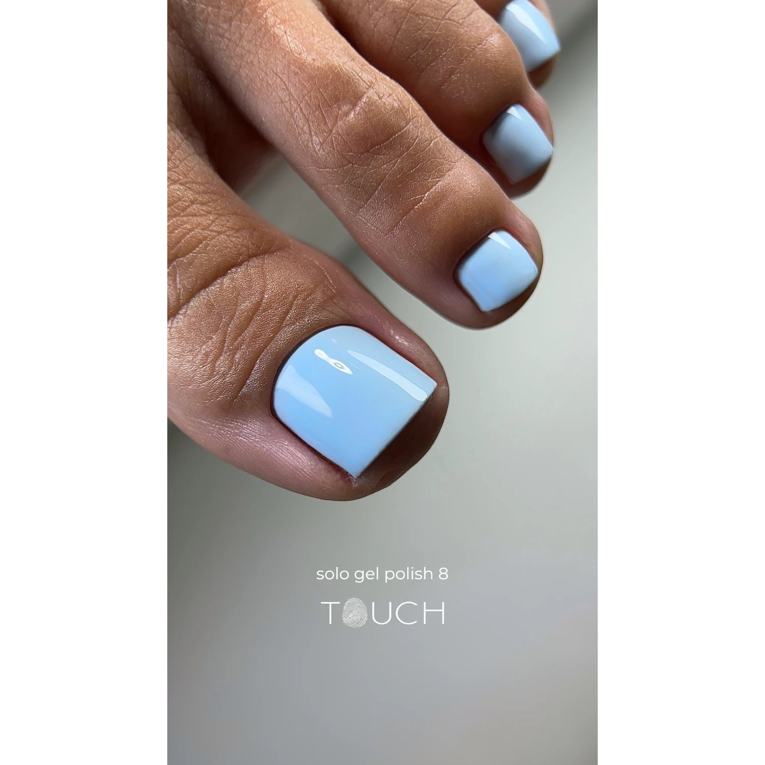 Close-up of toenails with glossy light blue gel polish pedicure