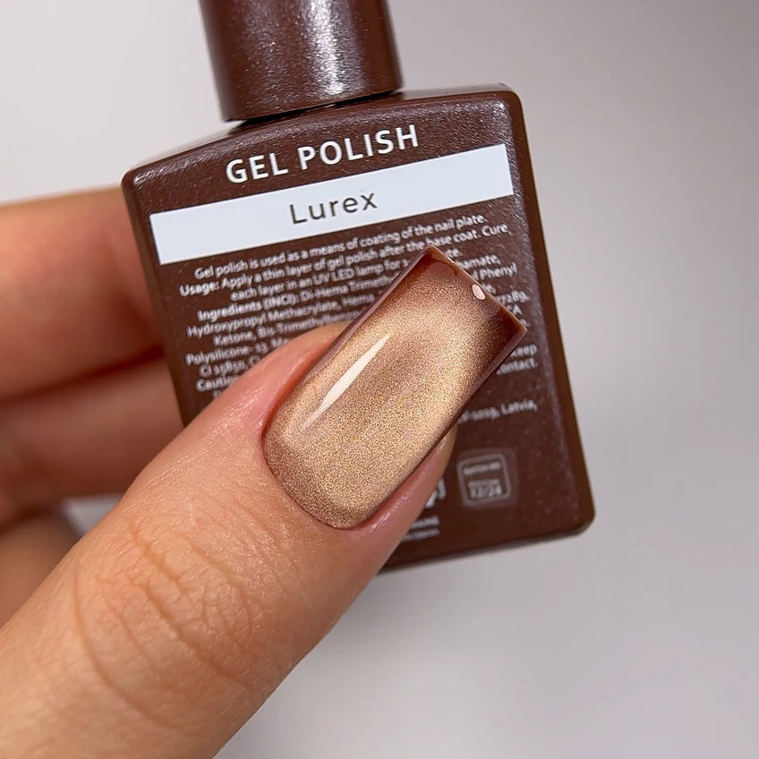 Hand with metallic gold gel polish manicure holding Lurex UV gel polish bottle