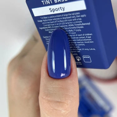 Hand with almond-shaped nail painted glossy deep blue gel polish, holding matching bottle