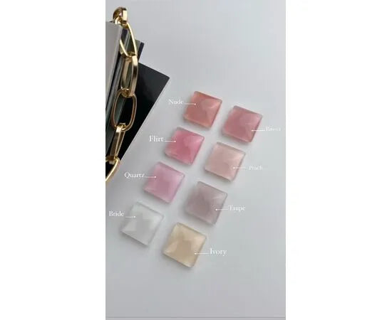 Nine square nail color samples in soft pink, nude, and ivory shades on a white background