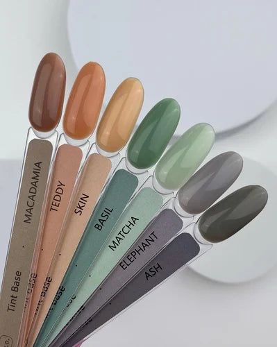 Palette of nail polish color samples in natural, green, and gray shades on labeled swatches.