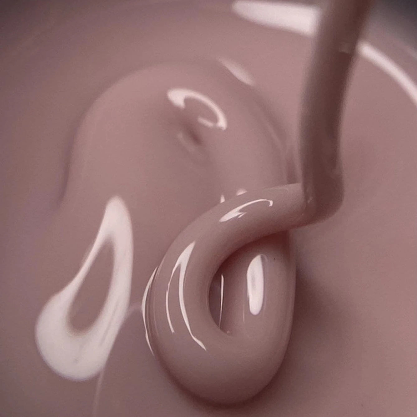 Close-up of nude pink UV gel for nails with glossy texture, manicure product